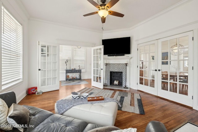 living area featuring crown molding, hardwood / wood-style flooring, ceiling fan, and french doors