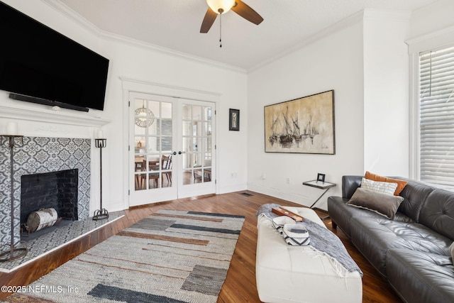 living room with baseboards, ceiling fan, wood finished floors, ornamental molding, and french doors