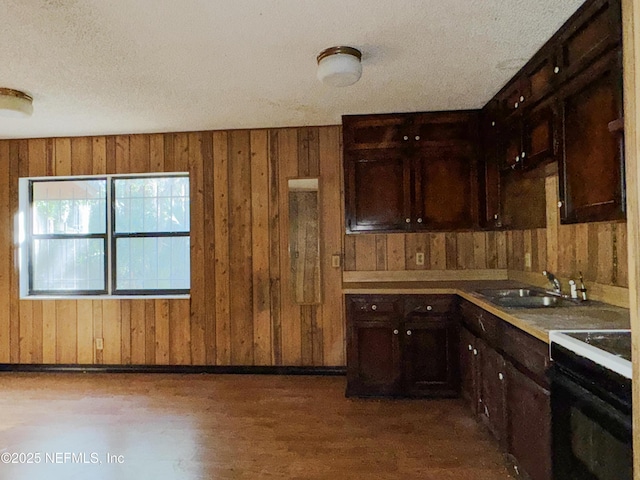 kitchen featuring dark brown cabinetry, black electric range, sink, and a textured ceiling