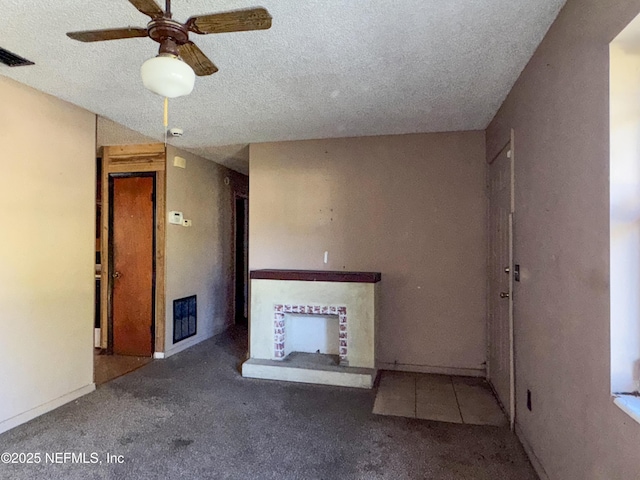 unfurnished living room with ceiling fan, a textured ceiling, and carpet