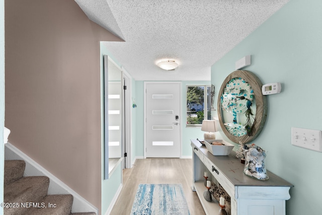 foyer featuring light hardwood / wood-style floors and a textured ceiling