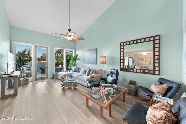 living room with ceiling fan, high vaulted ceiling, and light hardwood / wood-style floors