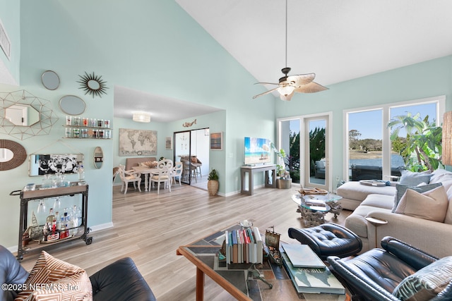 living room featuring high vaulted ceiling, light hardwood / wood-style floors, and ceiling fan