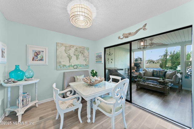 dining area featuring a textured ceiling and light wood-type flooring