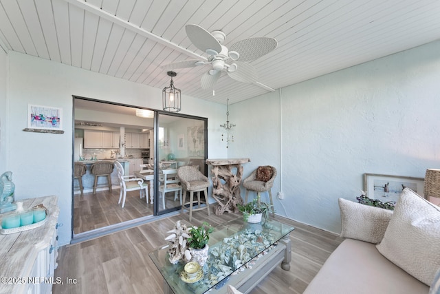 living room featuring ceiling fan, light hardwood / wood-style floors, and wooden ceiling