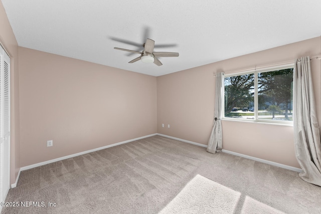 empty room with light colored carpet and ceiling fan