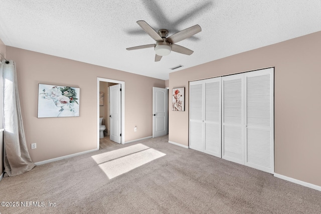 unfurnished bedroom with ceiling fan, light colored carpet, a textured ceiling, and a closet