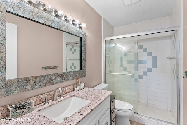 bathroom with walk in shower, vanity, toilet, and a textured ceiling