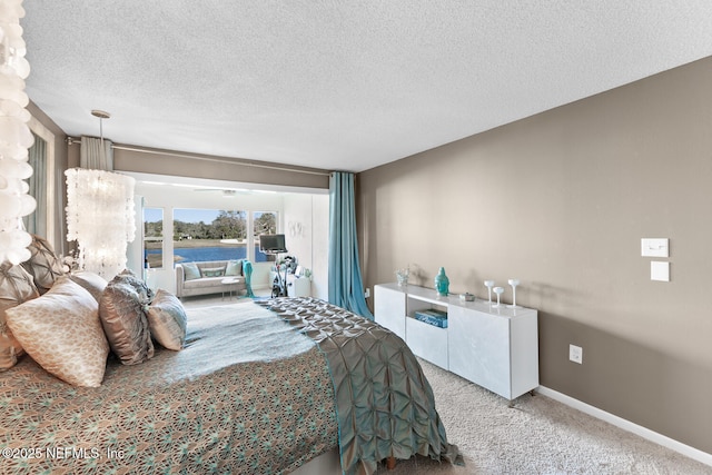 carpeted bedroom with a textured ceiling and access to outside