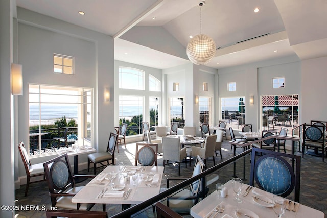 dining room featuring an inviting chandelier, high vaulted ceiling, and a healthy amount of sunlight