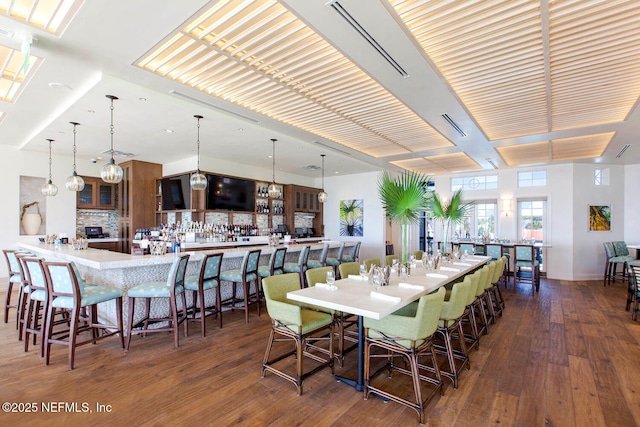 dining area featuring a stone fireplace and dark hardwood / wood-style floors