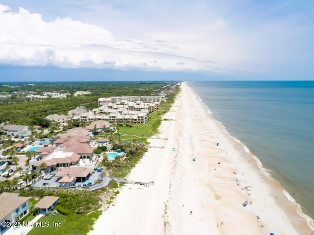 birds eye view of property with a water view and a beach view