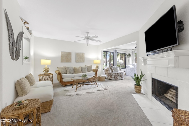 living room with ceiling fan, a fireplace, and light colored carpet