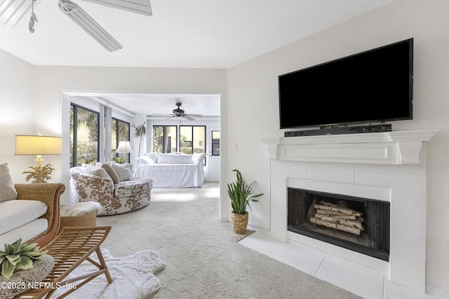 carpeted living room featuring a fireplace and ceiling fan