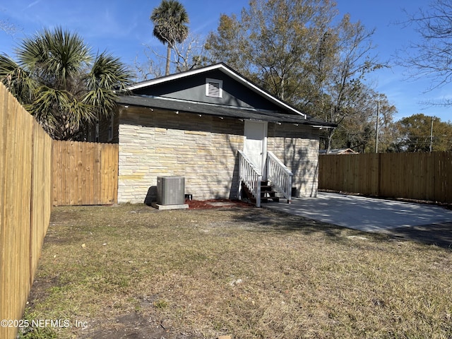 exterior space with cooling unit and a lawn