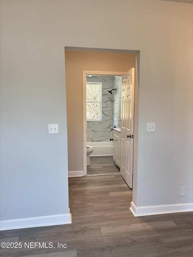 hallway with dark hardwood / wood-style flooring