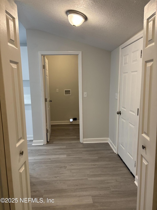 hall with wood-type flooring and a textured ceiling