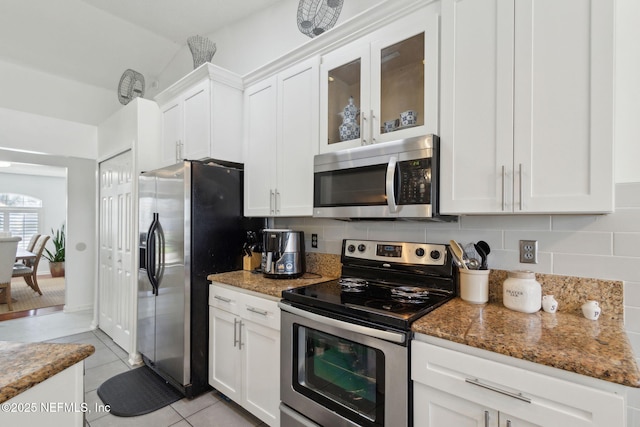 kitchen featuring light tile patterned floors, tasteful backsplash, appliances with stainless steel finishes, and white cabinets