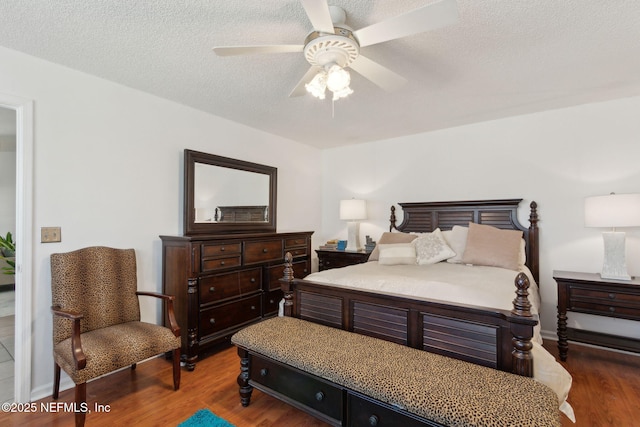 bedroom featuring ceiling fan, wood finished floors, and a textured ceiling