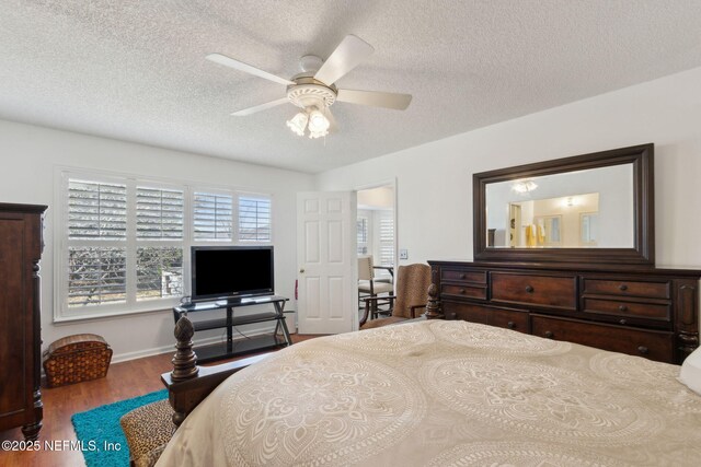 bedroom with a textured ceiling, wood finished floors, and ceiling fan