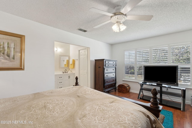 bedroom with visible vents, a textured ceiling, and wood finished floors