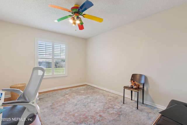 office with baseboards, a textured ceiling, and a ceiling fan