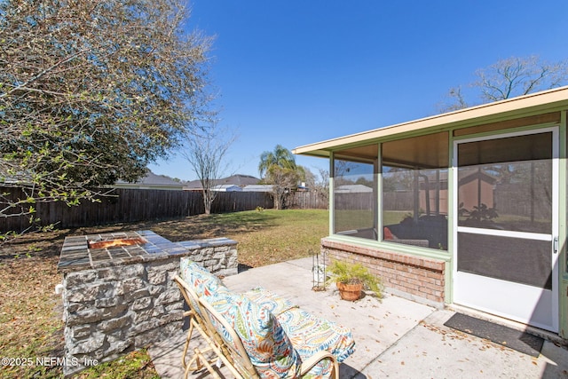 view of patio featuring a fenced backyard and a sunroom