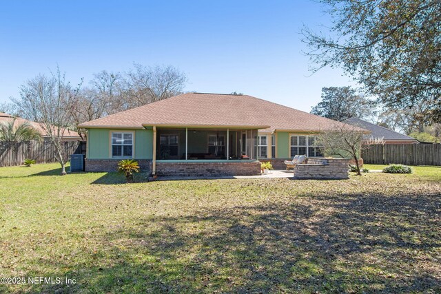 back of property with a shingled roof, a lawn, a fenced backyard, a sunroom, and a patio area