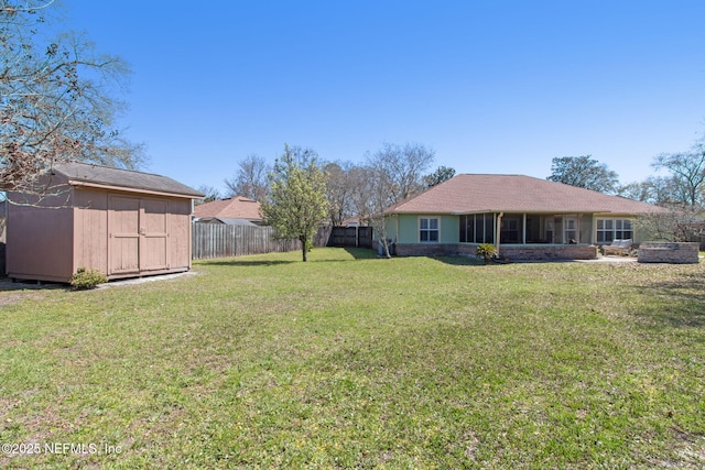 view of yard featuring an outbuilding, fence, and a shed