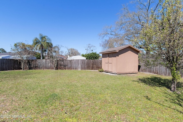 view of yard with an outdoor structure, a fenced backyard, and a shed