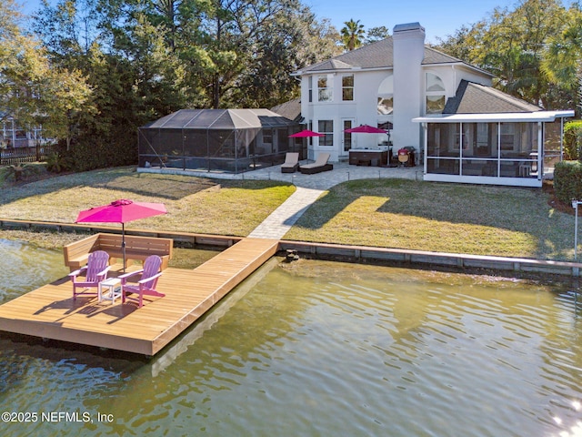 dock area with a lanai, a lawn, and a water view