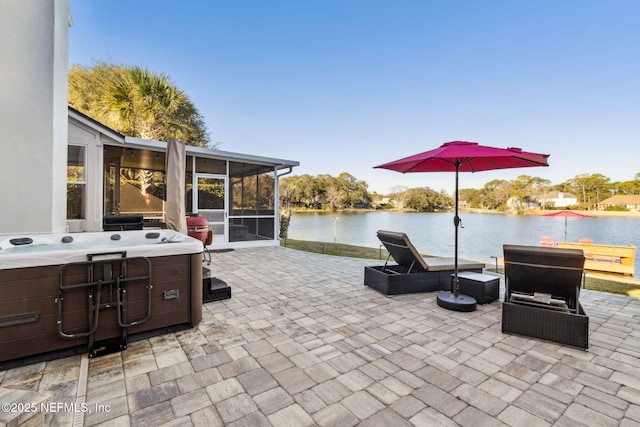 view of patio with a sunroom, a hot tub, and a water view