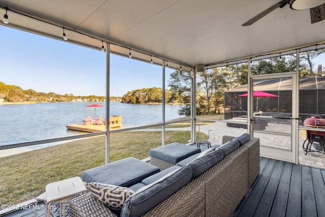 sunroom / solarium featuring a water view, a healthy amount of sunlight, and ceiling fan