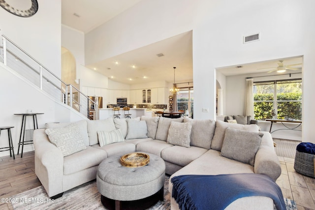 living room with a wealth of natural light, high vaulted ceiling, and light hardwood / wood-style floors