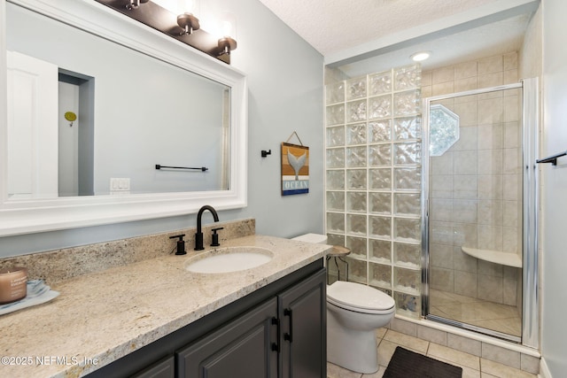 bathroom featuring vanity, toilet, a shower with door, tile patterned floors, and a textured ceiling