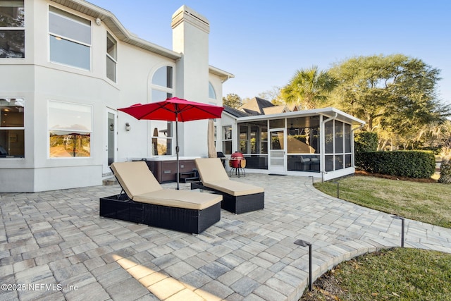 view of patio featuring a sunroom and a hot tub