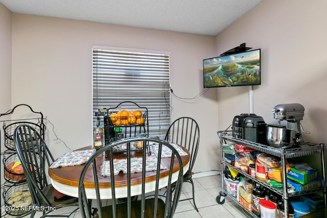 dining area featuring a textured ceiling and light tile patterned flooring