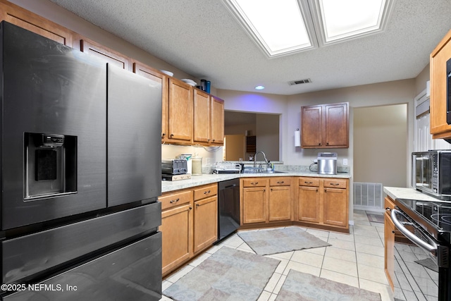 kitchen featuring light tile patterned flooring, dishwasher, sink, stainless steel fridge, and a textured ceiling