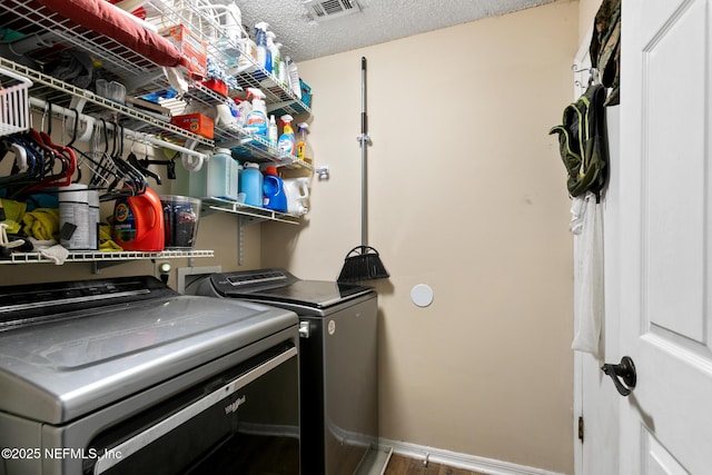 clothes washing area featuring washer and dryer and a textured ceiling