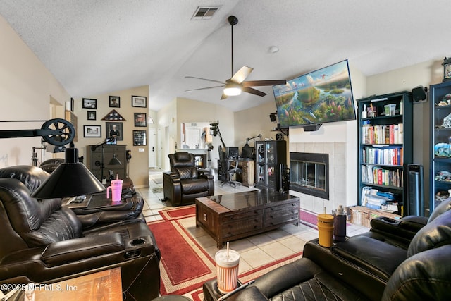 living room with a fireplace, vaulted ceiling, a textured ceiling, and light tile patterned floors