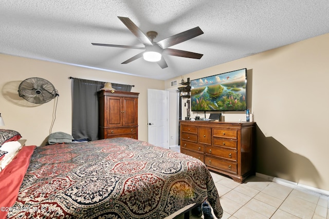 tiled bedroom with ceiling fan and a textured ceiling