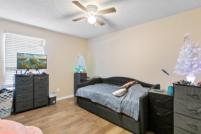 bedroom featuring ceiling fan, a textured ceiling, and light hardwood / wood-style flooring