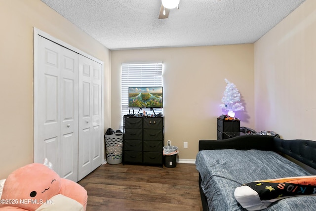 bedroom featuring dark hardwood / wood-style flooring, ceiling fan, a closet, and a textured ceiling