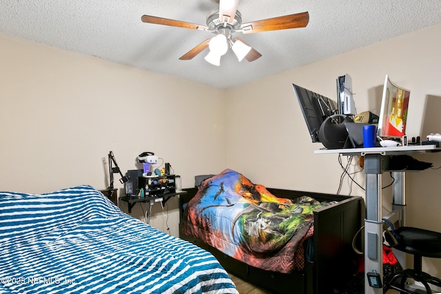 bedroom with ceiling fan and a textured ceiling