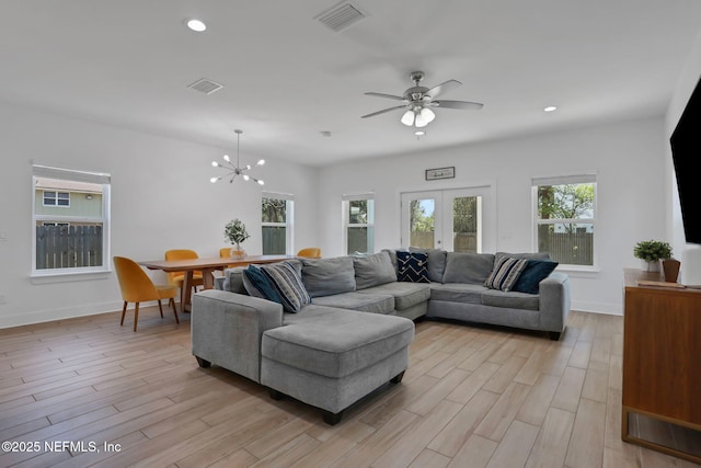 living room featuring a healthy amount of sunlight, light wood-type flooring, and french doors