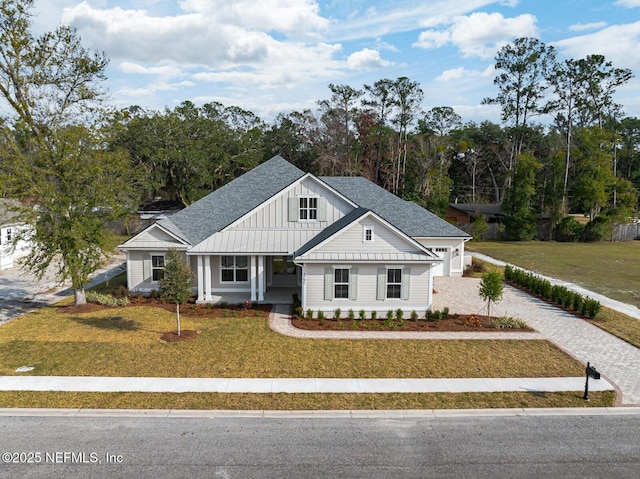 modern farmhouse featuring a garage and a front lawn