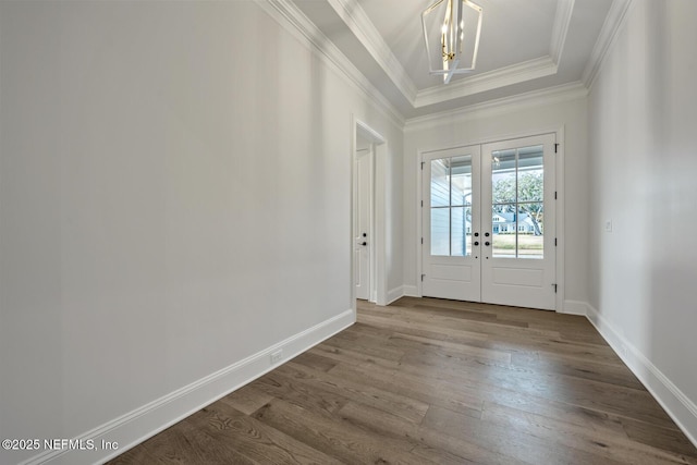 entryway with hardwood / wood-style floors, ornamental molding, french doors, and a raised ceiling