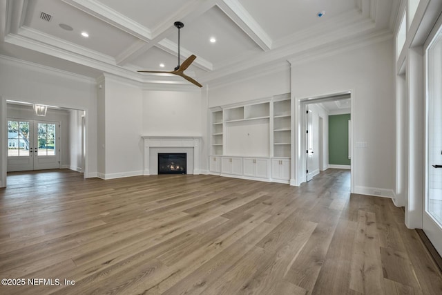 unfurnished living room featuring hardwood / wood-style floors, coffered ceiling, crown molding, beam ceiling, and french doors