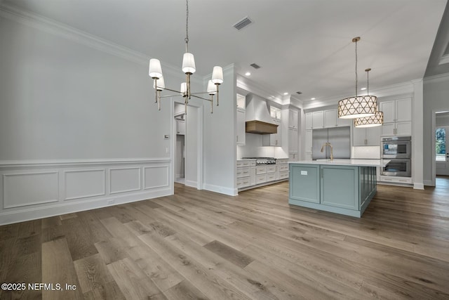 kitchen with double oven, hanging light fixtures, tasteful backsplash, and custom range hood