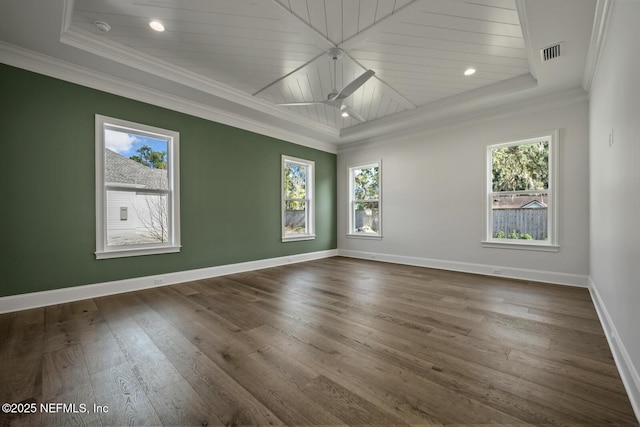 unfurnished room featuring crown molding, plenty of natural light, and a raised ceiling